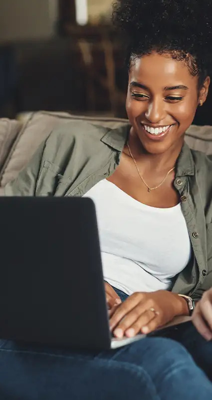 Eine fröhliche Frau findet online eine günstige Anschlussfinanzierung