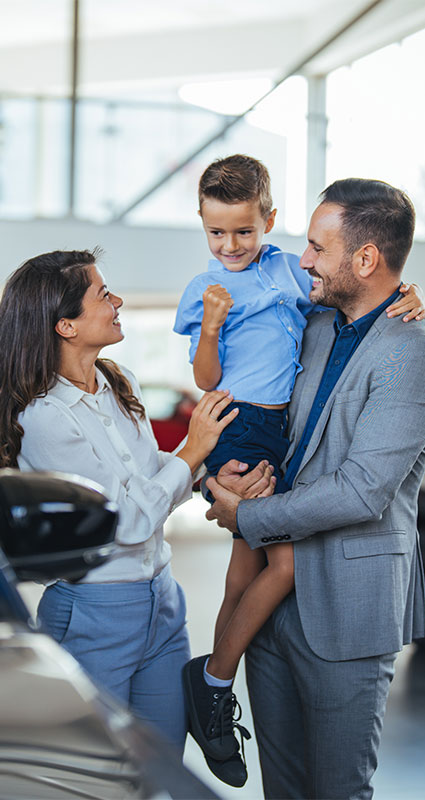 Eine junge Familie freut sich über die Auswahl ihres neuen Fahrzeugs.
