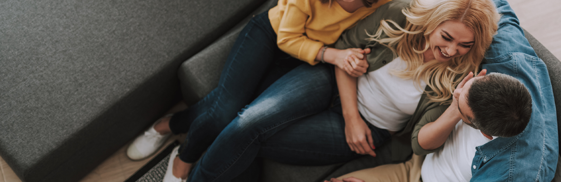 Eine Familie sitzt glücklich und lachend auf der Couch