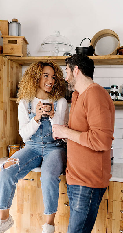 Auch für die Kücheneinrichtung kann man ein Darlehen aufnehmen. Zwei Menschen diskutieren in der Küche über ihr Darlehen.