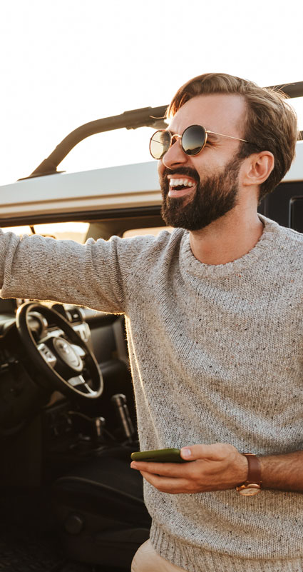 Ein lachender Mann hat gerade sein Auto über einen Privatkredit finanziert