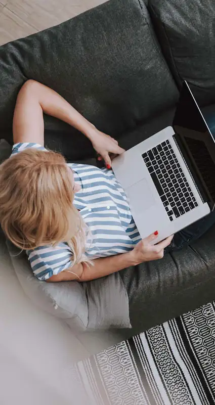 Eine Frau sucht an einem Laptop die optimale Anschlussfinanzierung