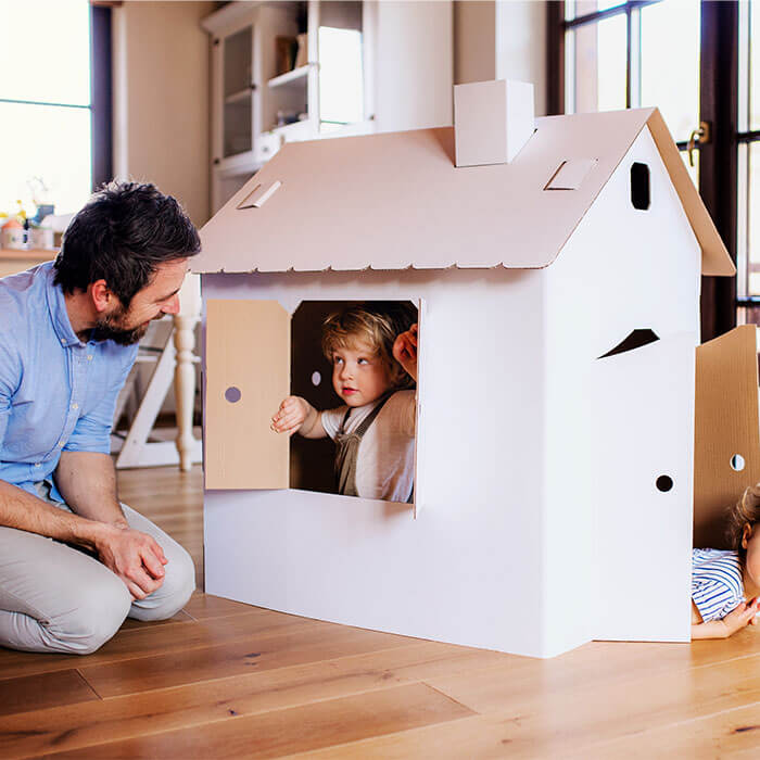Ein Vater spielt mit seinem Kind in einem Spielhaus