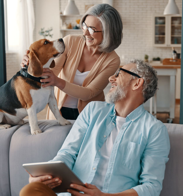 Ehepaar mit Hund freut sich, denn es konnte günstig seine Immobilie beleihen.