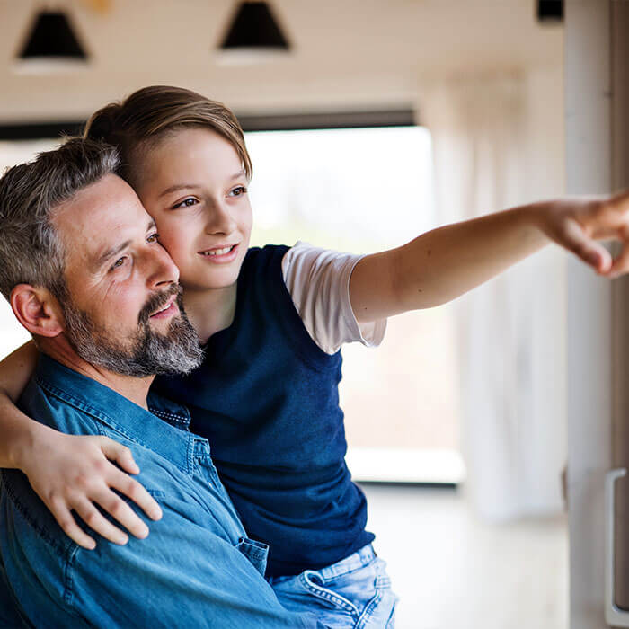 Ein Sohn sitzt auf dem Schoß seines Vaters und zeigt ihm etwas