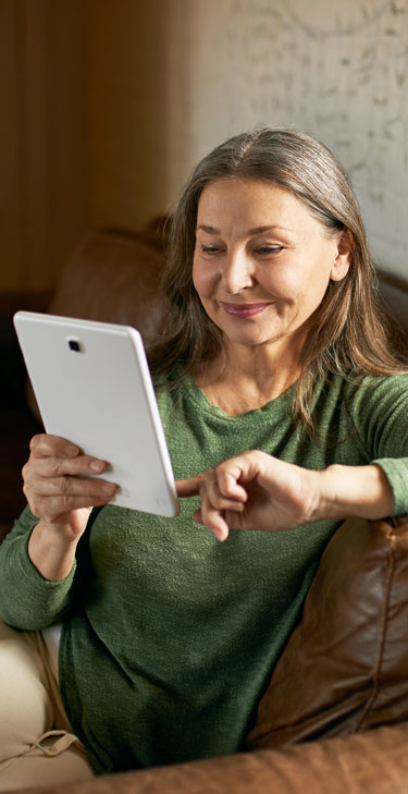 Eine Frau informiert sich auf dem Tablet über ihren Kredit