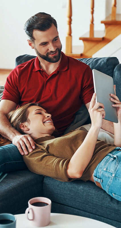 Ein Paar informiert sich am Tablet über die zahlreichen Kreditangebote von KREDIT.DE.