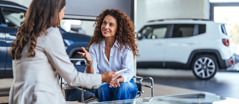 Zwei Frauen besprechen im Autohaus die Ballonfinanzierung für ein Fahrzeug.