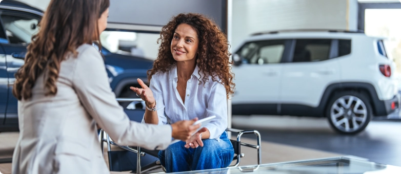 Zwei Frauen besprechen im Autohaus die Ballonfinanzierung für ein Fahrzeug.