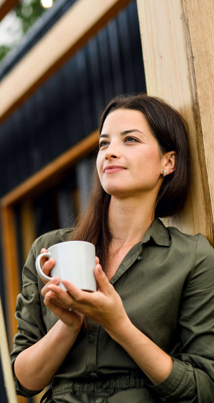 Eine Frau die entspannt eine Tasse Kaffee trinkt