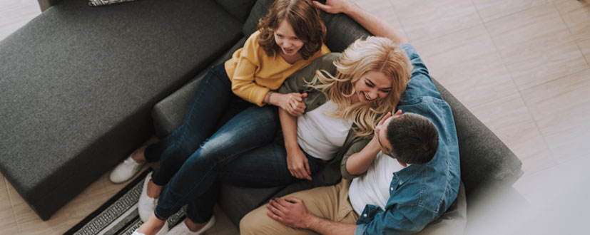 Eine junge Familie sitzt zusammen auf einem Sofa